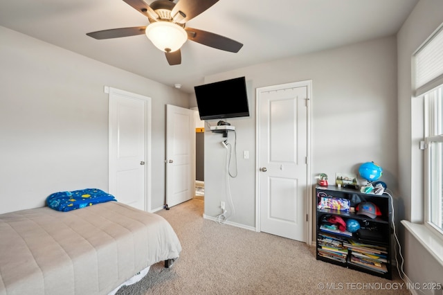 carpeted bedroom with multiple windows, baseboards, and a ceiling fan