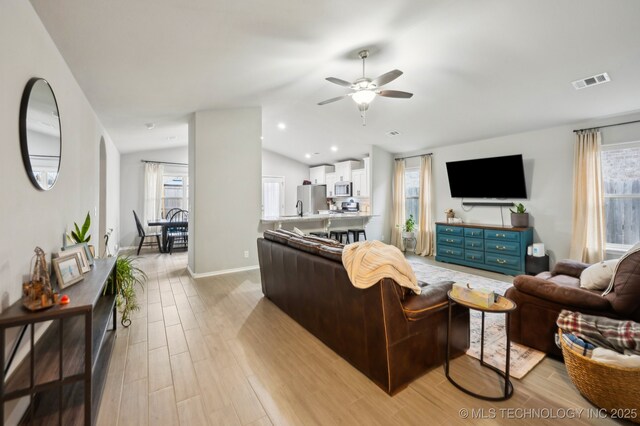 5117 S Nassau Ave, Sand Springs, OK 74063 - living room featuring ceiling fan, light wood-style flooring, vaulted ceiling, and healthy amount of natural light