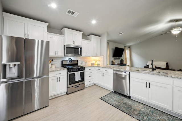 5117 S Nassau Ave, Sand Springs, OK 74063 - kitchen with appliances with stainless steel finishes, backsplash, white cabinets, ceiling fan, and light wood finished floors