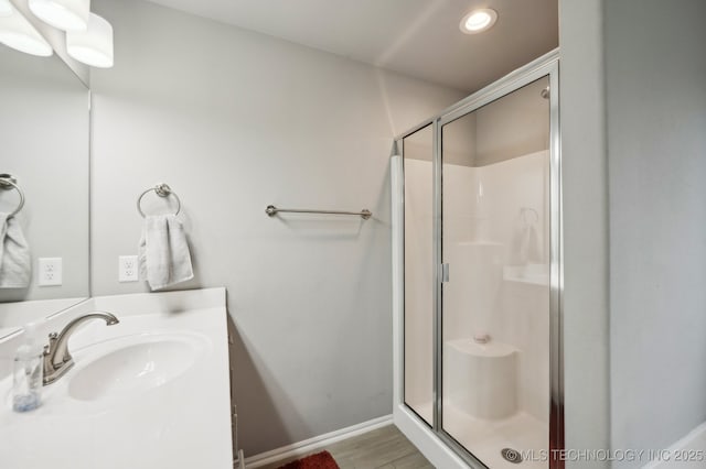 full bathroom with baseboards, recessed lighting, a stall shower, wood finished floors, and vanity