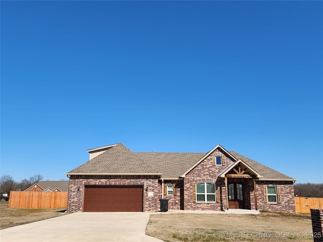 craftsman-style home featuring an attached garage, fence, brick siding, and driveway