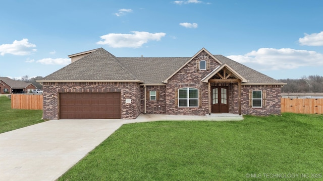 view of front of property featuring a front lawn, an attached garage, fence, and brick siding