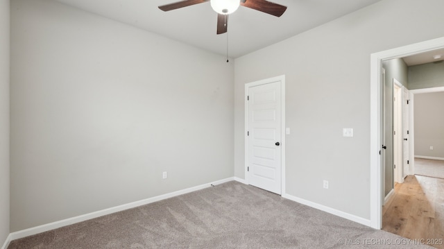 unfurnished bedroom featuring light colored carpet, baseboards, and ceiling fan