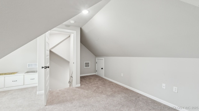 additional living space featuring baseboards, visible vents, and light carpet