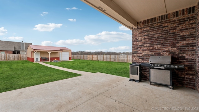 view of patio / terrace with an outbuilding, grilling area, and a fenced backyard