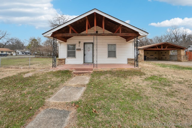 bungalow-style house with a front yard and fence