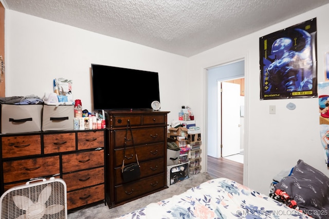 bedroom with light carpet and a textured ceiling