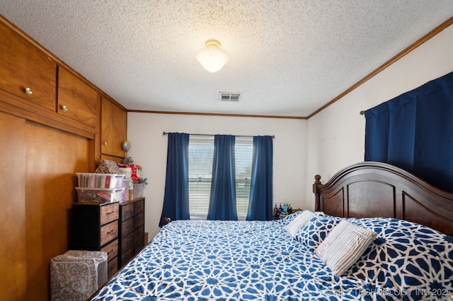 bedroom featuring visible vents, a textured ceiling, and ornamental molding