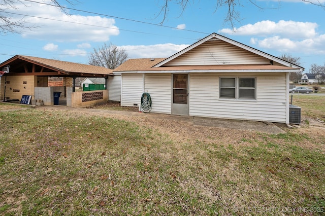 rear view of house with cooling unit and a yard