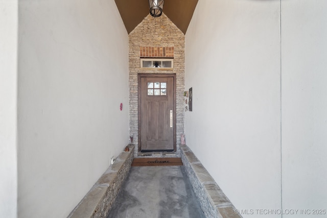 doorway to property featuring stone siding and stucco siding
