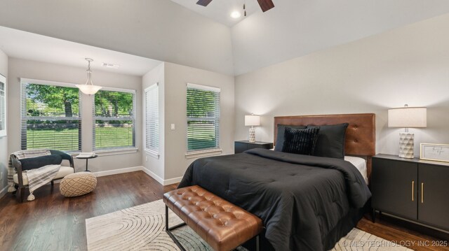 bedroom featuring baseboards, wood finished floors, lofted ceiling, and a ceiling fan