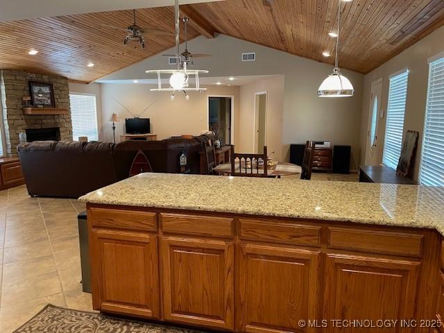 kitchen with light stone counters, visible vents, wood ceiling, and open floor plan