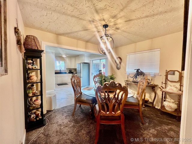 dining area with a textured ceiling and carpet