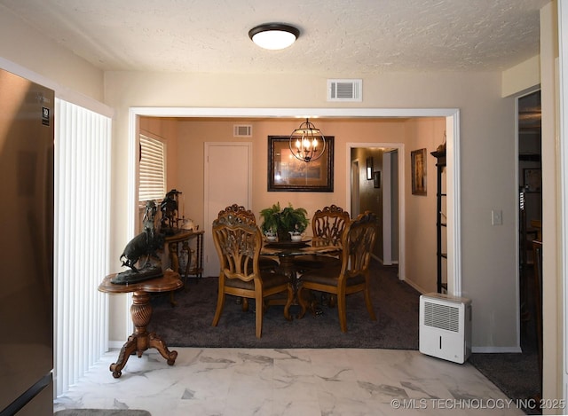 dining space with visible vents, marble finish floor, a textured ceiling, and an inviting chandelier