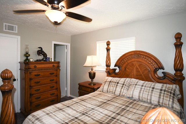 bedroom with a ceiling fan, visible vents, and a textured ceiling