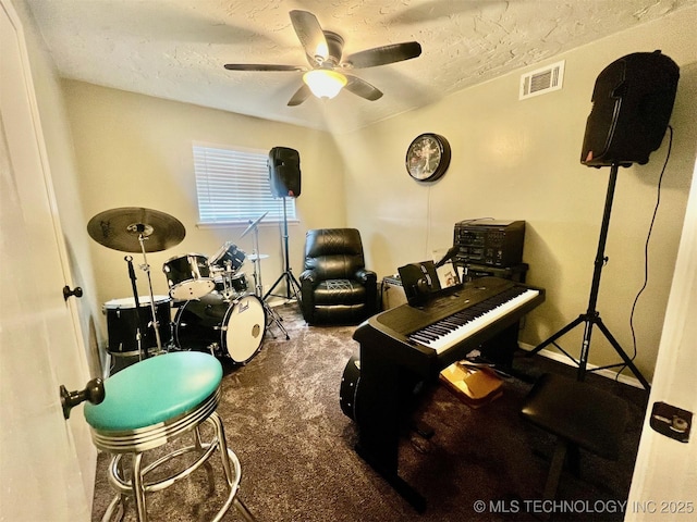 miscellaneous room with carpet flooring, a ceiling fan, visible vents, and a textured ceiling