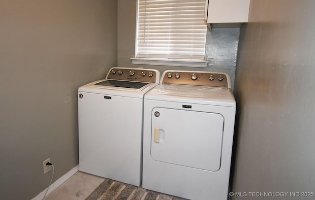 clothes washing area with laundry area, washing machine and dryer, and baseboards