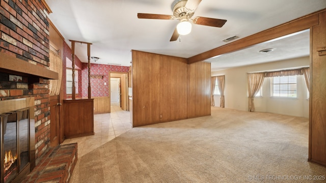 living room with a ceiling fan, carpet, a fireplace, and wallpapered walls