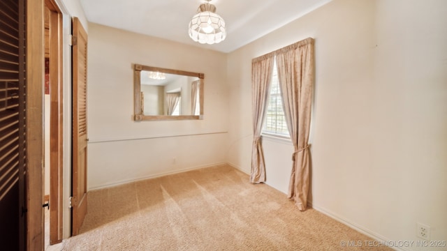 empty room featuring baseboards and carpet flooring