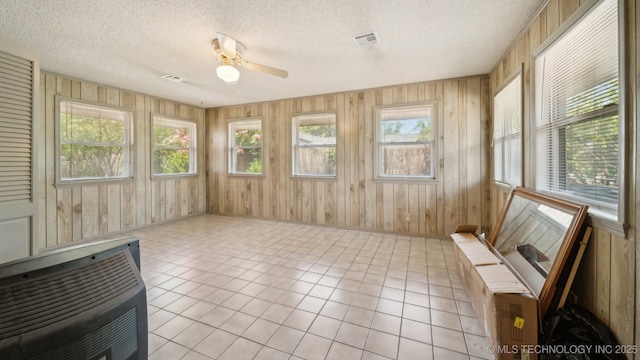 sunroom / solarium with heating unit, a ceiling fan, visible vents, and plenty of natural light