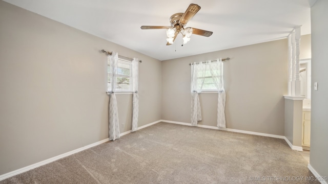 unfurnished room with carpet flooring, a ceiling fan, and baseboards