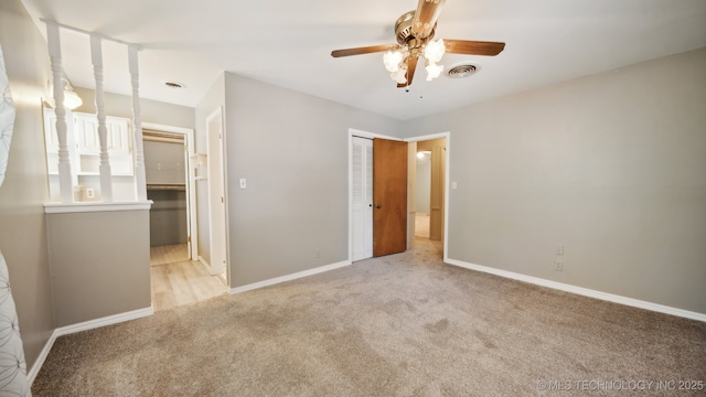 unfurnished bedroom featuring visible vents, light carpet, a ceiling fan, a closet, and baseboards