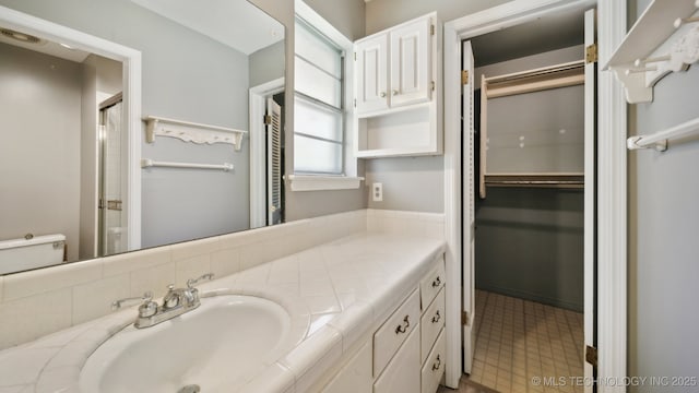 bathroom featuring an enclosed shower and vanity