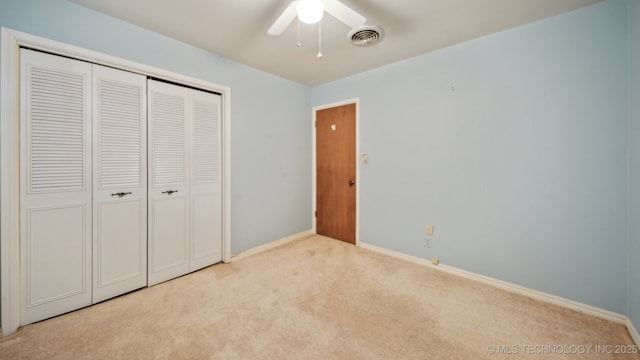 unfurnished bedroom with visible vents, a closet, carpet floors, baseboards, and ceiling fan