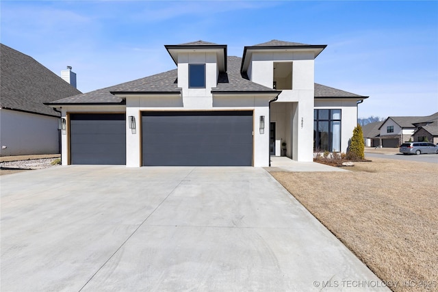 prairie-style house with a garage, roof with shingles, concrete driveway, and stucco siding