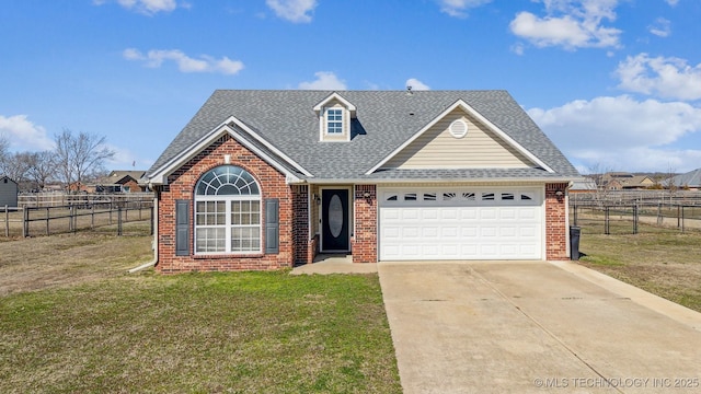 view of front facade featuring driveway, brick siding, roof with shingles, and a front yard