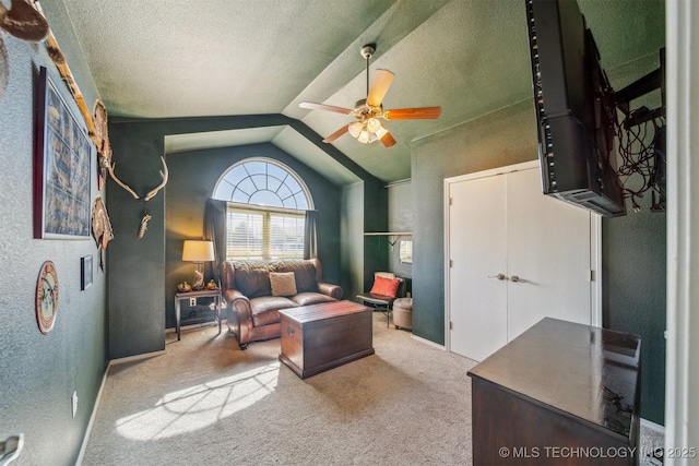 sitting room featuring a textured ceiling, carpet floors, lofted ceiling, ceiling fan, and a textured wall