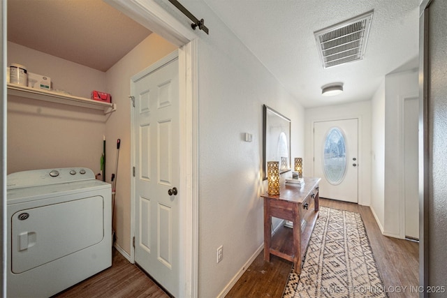 washroom with visible vents, washer / clothes dryer, wood finished floors, and laundry area