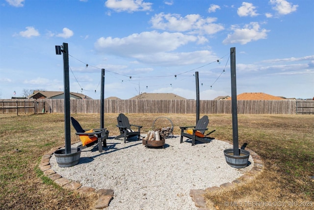 view of yard featuring a fire pit and a fenced backyard