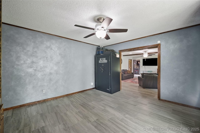 unfurnished room featuring wood finished floors, a textured ceiling, and ornamental molding