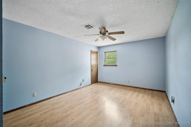 unfurnished room featuring visible vents, baseboards, wood finished floors, a textured ceiling, and a ceiling fan