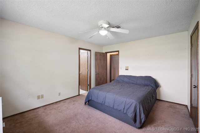 carpeted bedroom featuring ceiling fan, baseboards, visible vents, and a textured ceiling