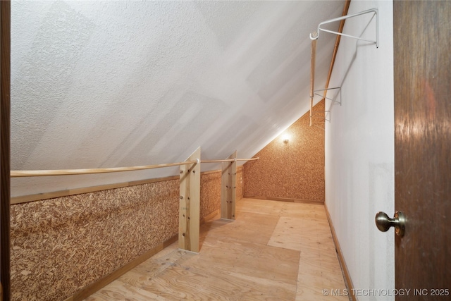 bonus room featuring a textured ceiling and lofted ceiling