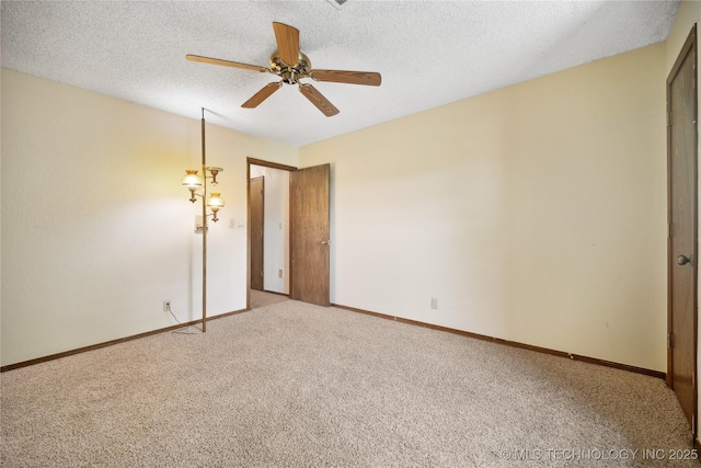 empty room with baseboards, carpet, ceiling fan, and a textured ceiling