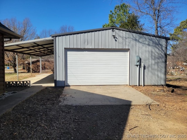 garage with driveway and a detached garage