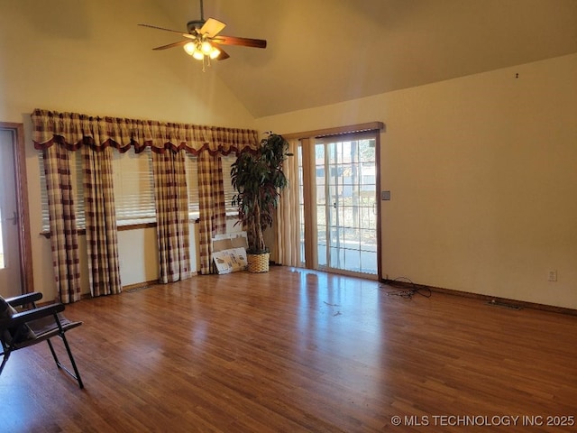 unfurnished living room with a ceiling fan, wood finished floors, baseboards, and high vaulted ceiling