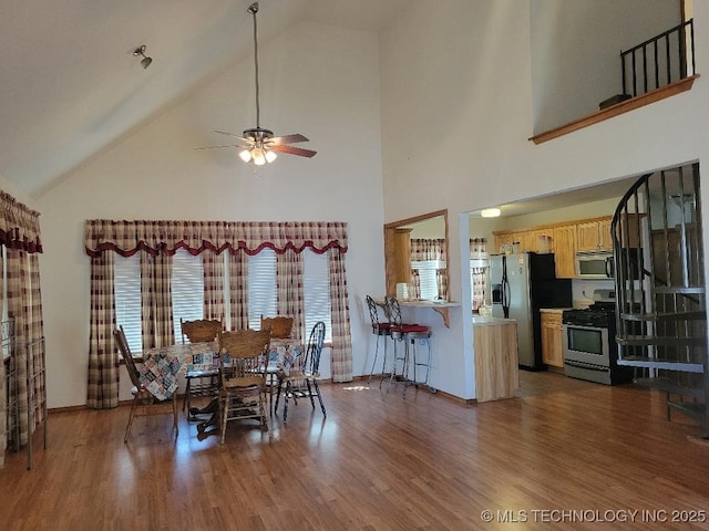 dining space featuring lofted ceiling, a ceiling fan, and wood finished floors