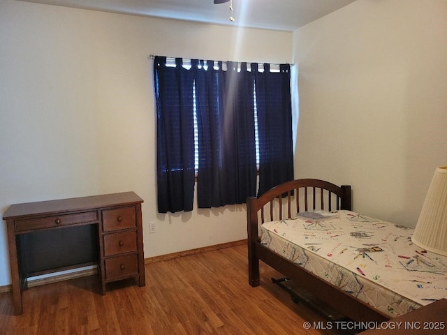 bedroom featuring baseboards and wood finished floors