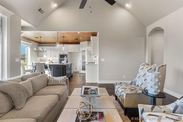 living area featuring visible vents, dark wood-type flooring, baseboards, high vaulted ceiling, and a ceiling fan