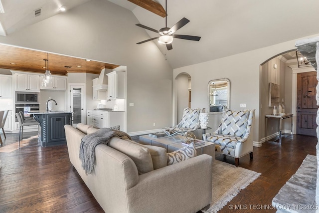 living area with visible vents, arched walkways, ceiling fan, and dark wood-style flooring