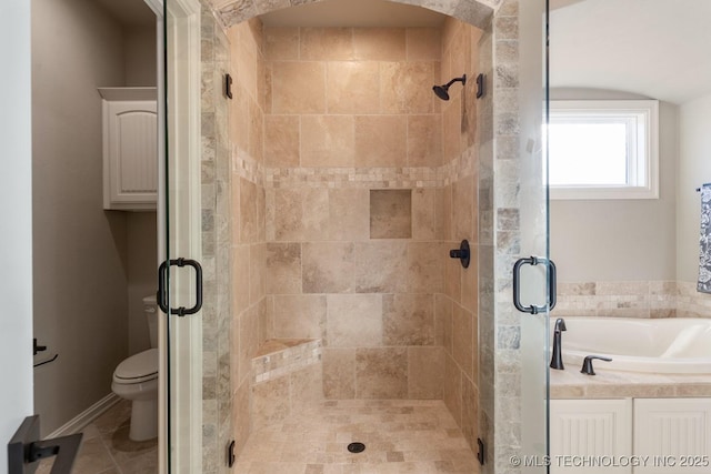 full bathroom featuring toilet, a stall shower, and a bath