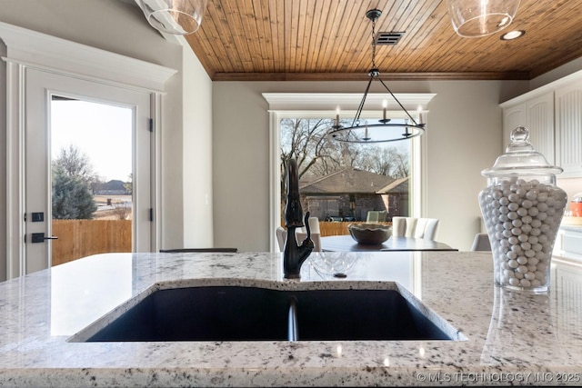 kitchen featuring visible vents, a sink, ornamental molding, pendant lighting, and wooden ceiling