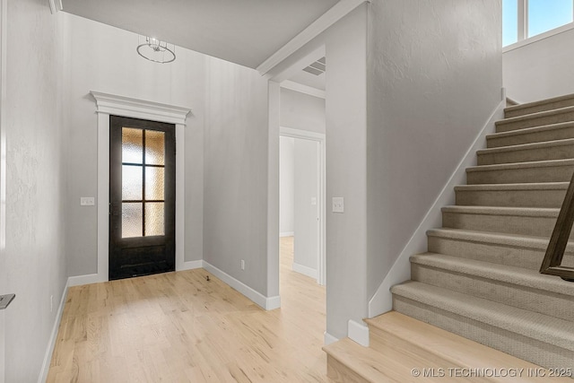 entrance foyer with stairs, wood finished floors, visible vents, and baseboards