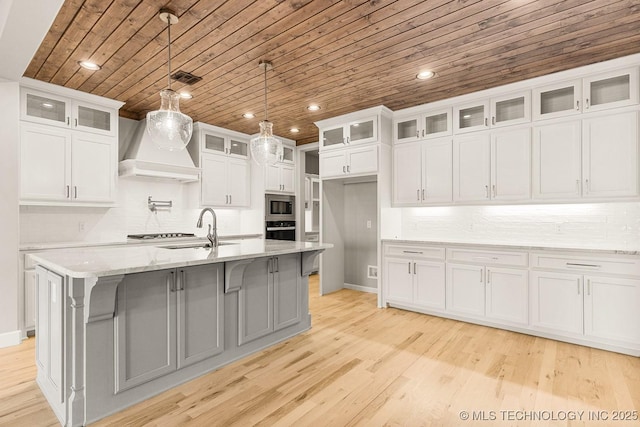 kitchen featuring a sink, custom range hood, wood ceiling, appliances with stainless steel finishes, and light wood-type flooring