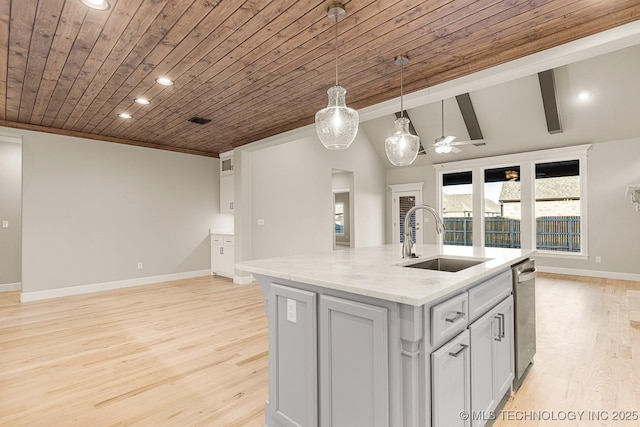 kitchen with light wood-style flooring, a sink, stainless steel dishwasher, light stone countertops, and hanging light fixtures