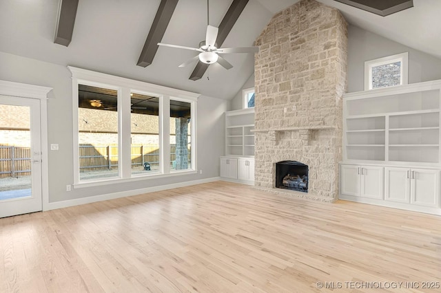 unfurnished living room with baseboards, beam ceiling, wood finished floors, and a fireplace